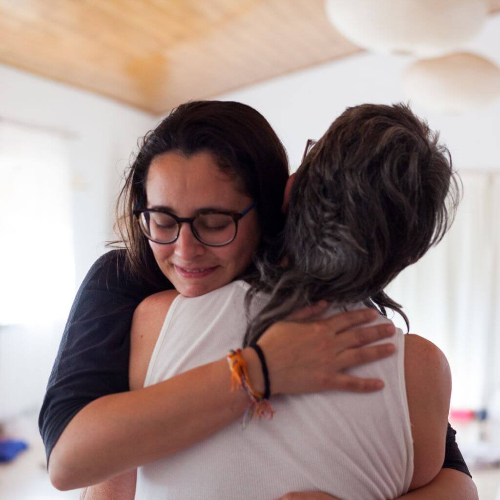 Mujeres abrazadas en un momento de conexión y entrega, en la Certificación en Sexualidad Femenina Taoísta – La Mujer Oceánica | Escuela de Mujeres
