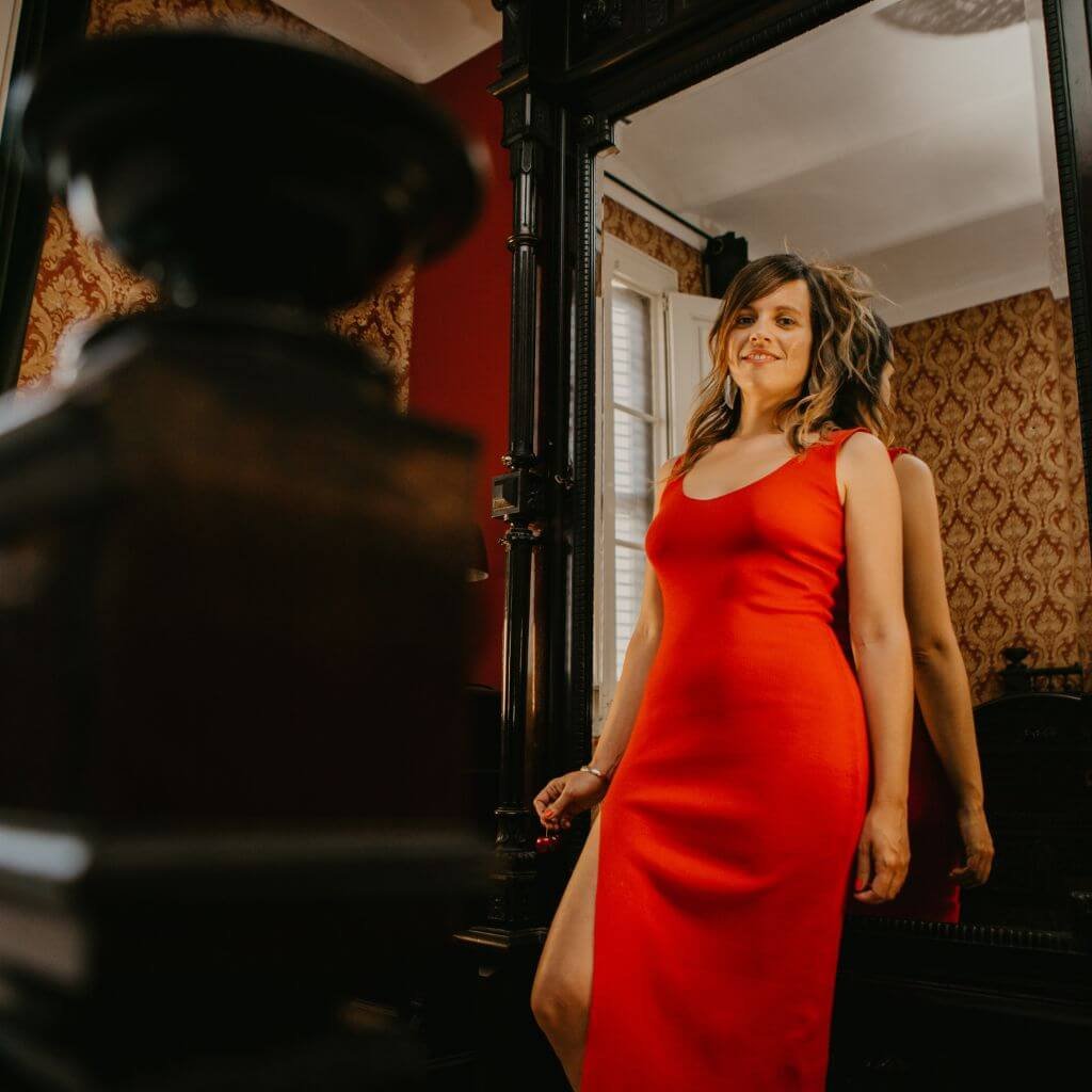 Myriam Peña de rojo frente al espejo, introduciendo el módulo de Huevo de Jade y el Arte de la Intimidad Femenina en la Certificación en Sexualidad Femenina Taoísta – La Mujer Oceánica | Escuela de Mujeres